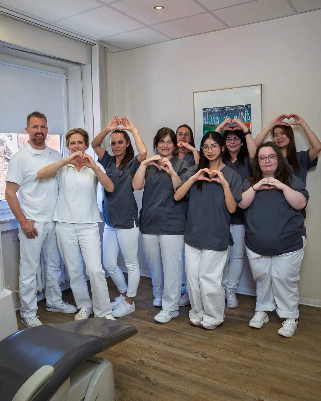 Das Team der Zahnarztpraxis Dres. Hunecke in Kitzingen formt Herzen mit den Händen